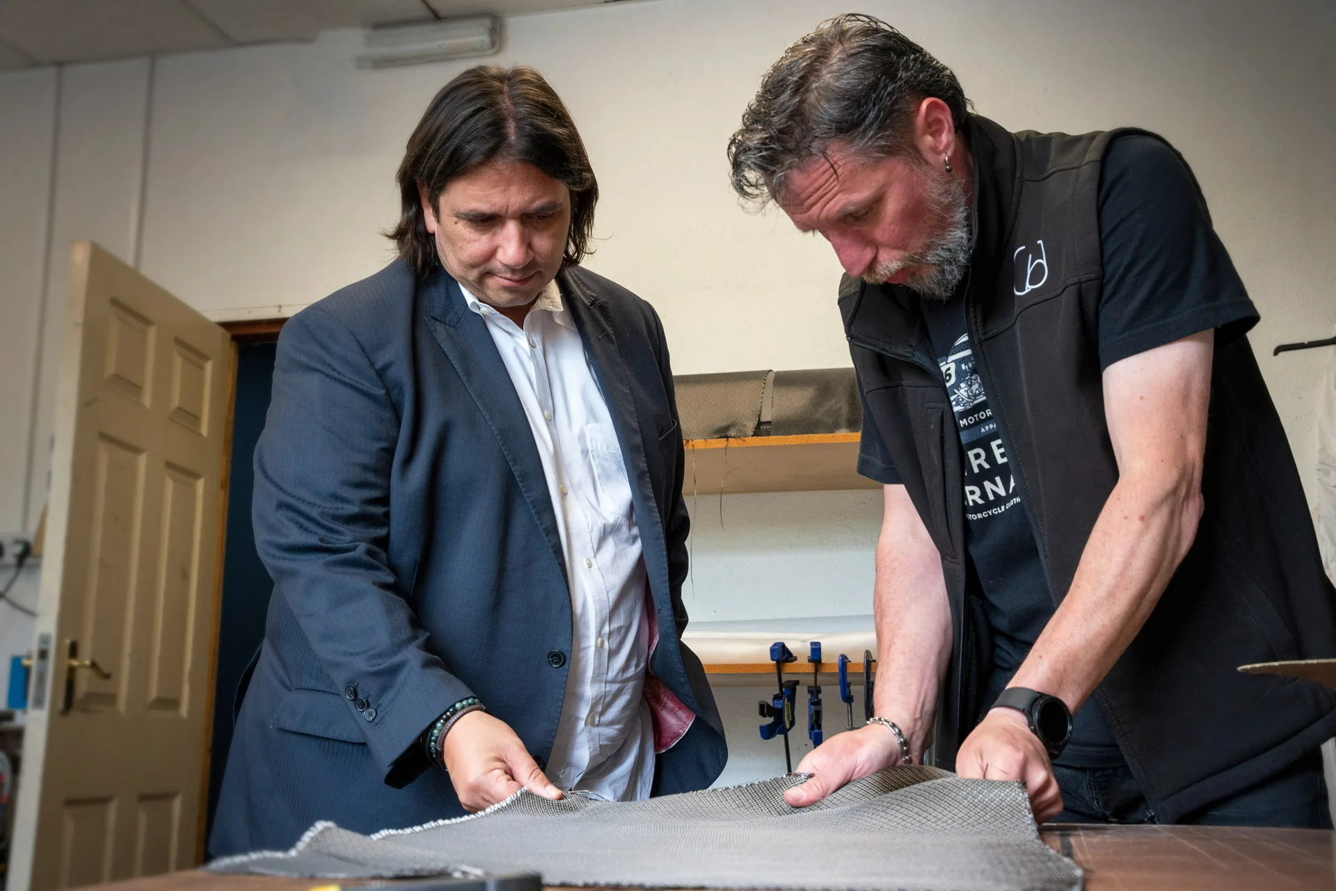 Composites Engineer Darren with George showing the unique carbon-PTFE fabric that Wilson Benesch developed specially and has woven exclusively for the company to allow the IGx and various other carbon composite components to be created in house at Wilson Benesch
