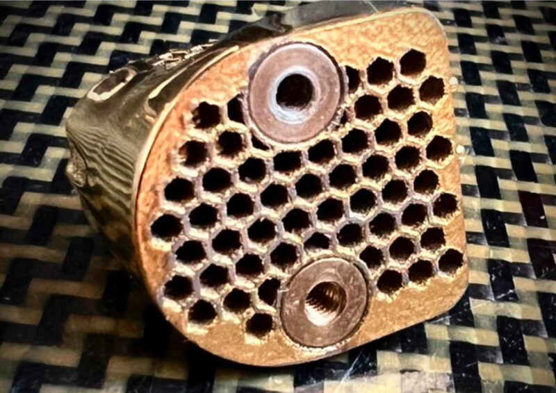 Top view of the TESSELLATE Ti Cartridge showing its tessellated honeycomb structure, designed to maximise surface contact and energy damping via viscoelastic adhesive bonding.